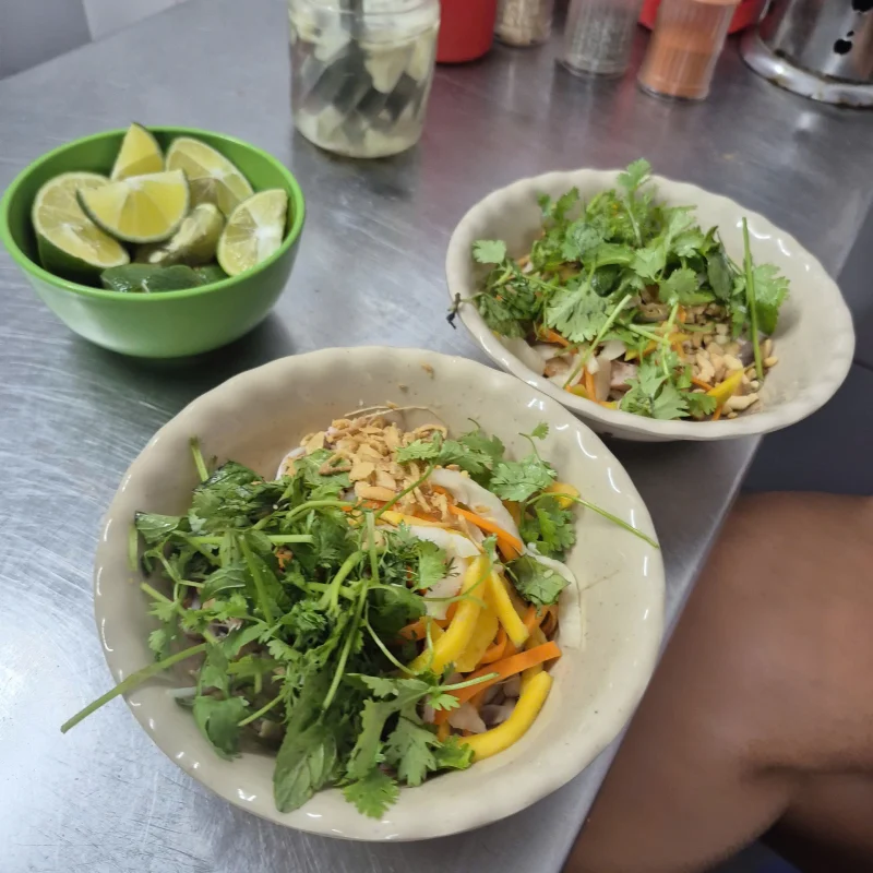 A fresh Hanoi street fruit salad made with green papaya, herbs, and chili, served by a local vendor in the Old Quarter